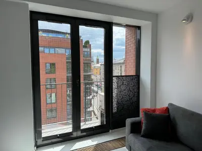 a living room with a couch and a large window at Black&White Angel Apartment in Kraków