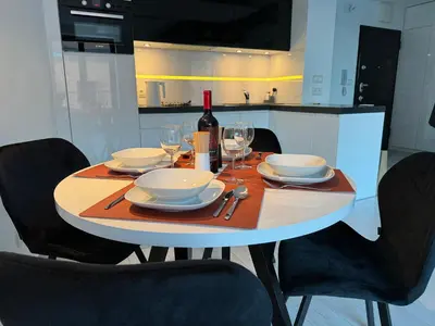 a dining table with a bottle of wine and glasses at Black&White Angel Apartment in Kraków