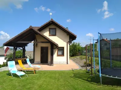 a small house with chairs and a trampoline at Morycówka in Rzyki