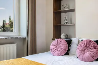 two pink pillows on a bed in a bedroom at Wavelo Apartments in Kraków