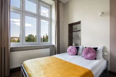 a bedroom with a bed with two purple pillows on it at Wavelo Apartments in Kraków
