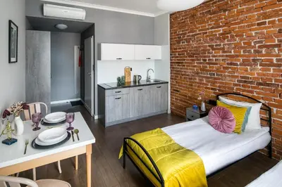 a room with a bed and a brick wall at Wavelo Apartments in Kraków
