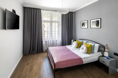 a bedroom with a bed and a tv on the wall at Wavelo Apartments in Kraków