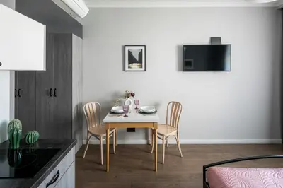 a kitchen with a table and chairs in a room at Wavelo Apartments in Kraków