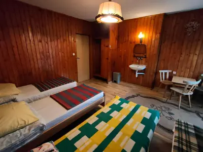 a bedroom with two beds and a table and a chair at Chata Pod Kwiatkiem in Zawoja