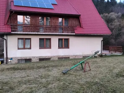 a house with a red roof with a green pole at Chata Pod Kwiatkiem in Zawoja