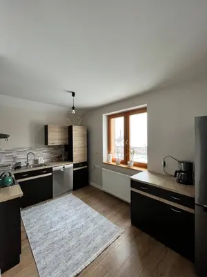 a kitchen with black cabinets and a large window at Dom w Beskidach in Zagórnik