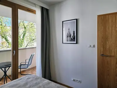 a bedroom with a door leading to a balcony at Old Town Plaza Apartment in Kraków