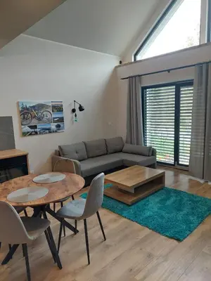 a living room with a couch and a table and chairs at Domek przy drodze in Chyszówki