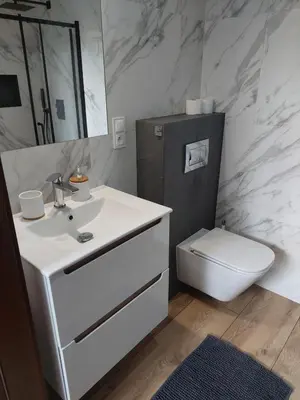 a bathroom with a white sink and a toilet at Domek przy drodze in Chyszówki