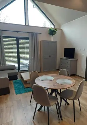 a living room with a table and chairs at Domek przy drodze in Chyszówki