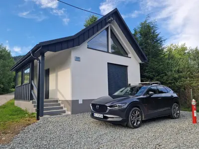 a small house with a car parked in front of it at Domek przy drodze in Chyszówki