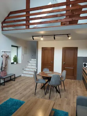 a living room with a wooden table and chairs at Domek przy drodze in Chyszówki