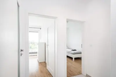 a room with white walls and a room with a bed at Tauron Arena Residence WAWELOFTS in Kraków