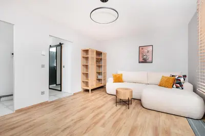 a living room with a white couch and wooden floors at Kraków Kazimierz Charm - by Upstairs in Kraków