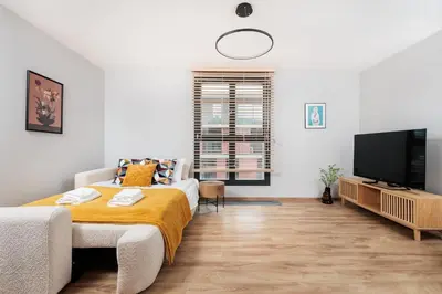 a bedroom with a bed and a flat screen tv at Kraków Kazimierz Charm - by Upstairs in Kraków