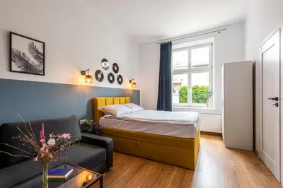 a small bedroom with a bed and a couch at St Florian Apartments in Kraków
