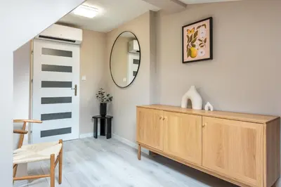 a room with a wooden dresser and a mirror at St Florian Apartments in Kraków