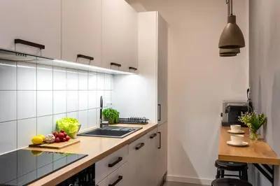 a kitchen with white cabinets and a counter with fruits on it at St Florian Apartments in Kraków