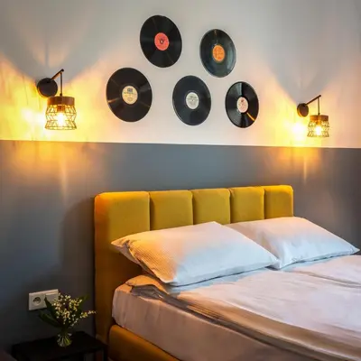 a bed with a bunch of records on the wall at St Florian Apartments in Kraków