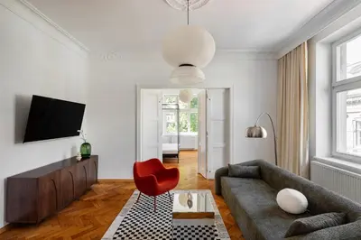 a living room with a couch and a red chair at St Florian Apartments in Kraków