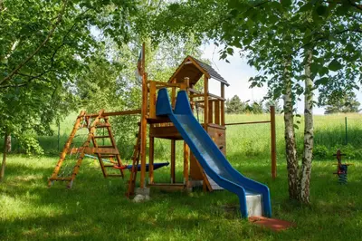 a large pool with a wooden deck with a blue pool at Noclegi Bajama in Siepraw