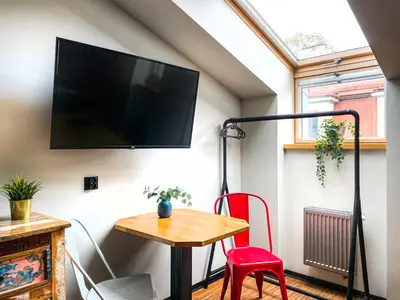 a living room with a table and a tv on a wall at Cozy apartment with AC for couples - Old Town in Kraków