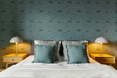 a bedroom with a bed and two nightstand tables with lamps at Cracow Palm Apartment in Kraków