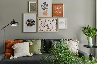 a living room with a gray couch with pillows at Cracow Palm Apartment in Kraków