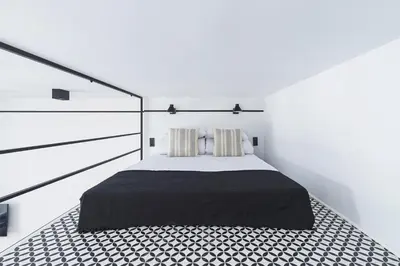 a white bedroom with a bed with a black blanket at Main Station - Radziwiłłowska 27 in Kraków