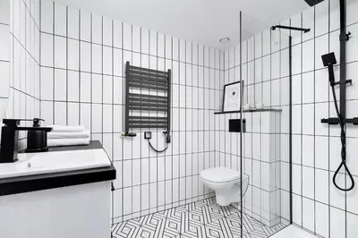 a white bathroom with a toilet and a shower at Main Station - Radziwiłłowska 27 in Kraków