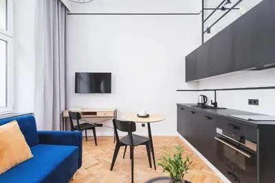 a living room with a blue couch and a table at Main Station - Radziwiłłowska 27 in Kraków