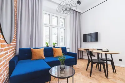 a living room with a blue couch and a table at Main Station - Radziwiłłowska 27 in Kraków