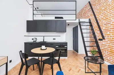 a kitchen with a table and chairs and a brick wall at Main Station - Radziwiłłowska 27 in Kraków