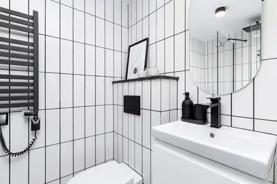 a white bathroom with a sink and a mirror at Studio apartment - Radziwiłłowska 27 in Kraków