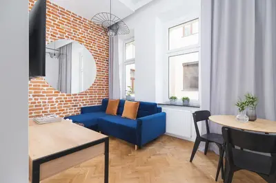 a living room with a blue couch and a table at Studio apartment - Radziwiłłowska 27 in Kraków