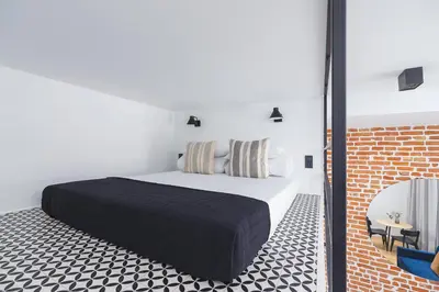 a bedroom with a bed and a brick wall at Studio apartment - Radziwiłłowska 27 in Kraków