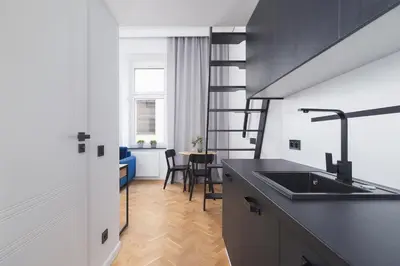 a kitchen with a sink and a dining room at Studio apartment - Radziwiłłowska 27 in Kraków