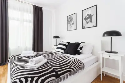 a white bedroom with a zebra print bed and a window at Krakowska 16 Street Kazimierz District in Kraków