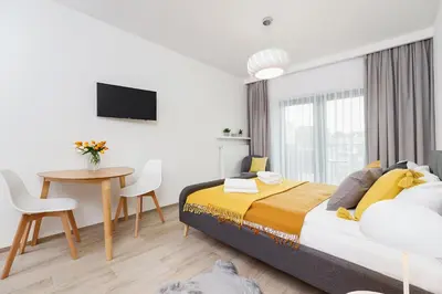 a bedroom with a bed and a table and a tv at Studio with balcony - Rajska 3 Street in Kraków