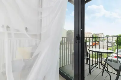 a balcony with a table and a white curtain at Studio with balcony - Rajska 3 Street in Kraków