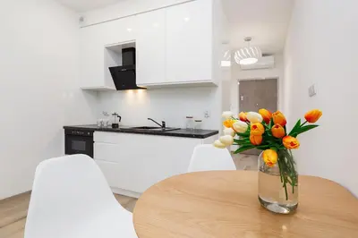 a vase of flowers sitting on a table in a kitchen at Studio with balcony - Rajska 3 Street in Kraków