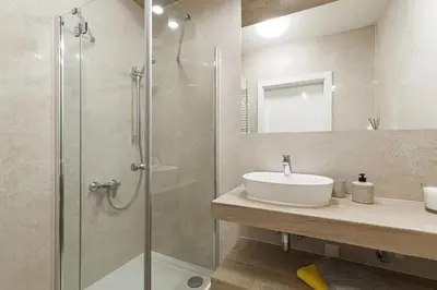 a bathroom with a sink and a glass shower at Studio with balcony - Rajska 3 Street in Kraków