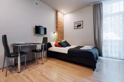 a bedroom with a bed and a desk and a table at Studio with balcony - Rzeszowska 4 Street in Kraków
