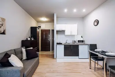 a living room with a couch and a kitchen at Studio with balcony - Rzeszowska 4 Street in Kraków