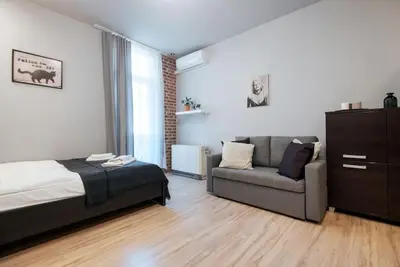 a bedroom with a bed and a couch at Studio with balcony - Rzeszowska 4 Street in Kraków