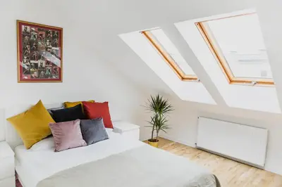 a living room with a white couch with colorful pillows at 1 - bedroom Apartment - Przemyska 4 Street in Kraków