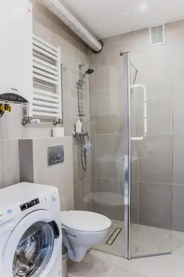 a bathroom with a washing machine and a toilet at 1 - bedroom Apartment - Przemyska 4 Street in Kraków