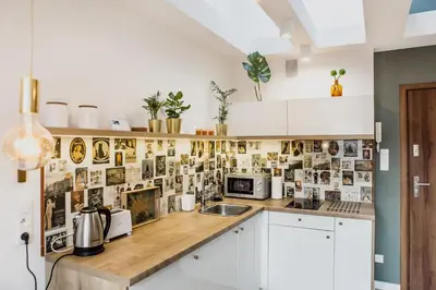 a kitchen with white cabinets and a wooden counter top at 1 - bedroom Apartment - Przemyska 4 Street in Kraków
