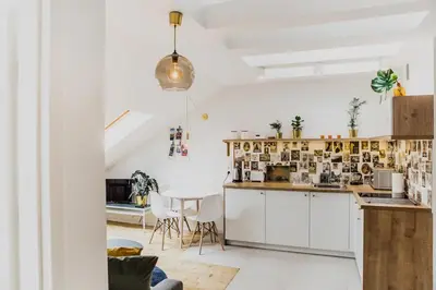 a kitchen and dining room with white cabinets and a table at 1 - bedroom Apartment - Przemyska 4 Street in Kraków